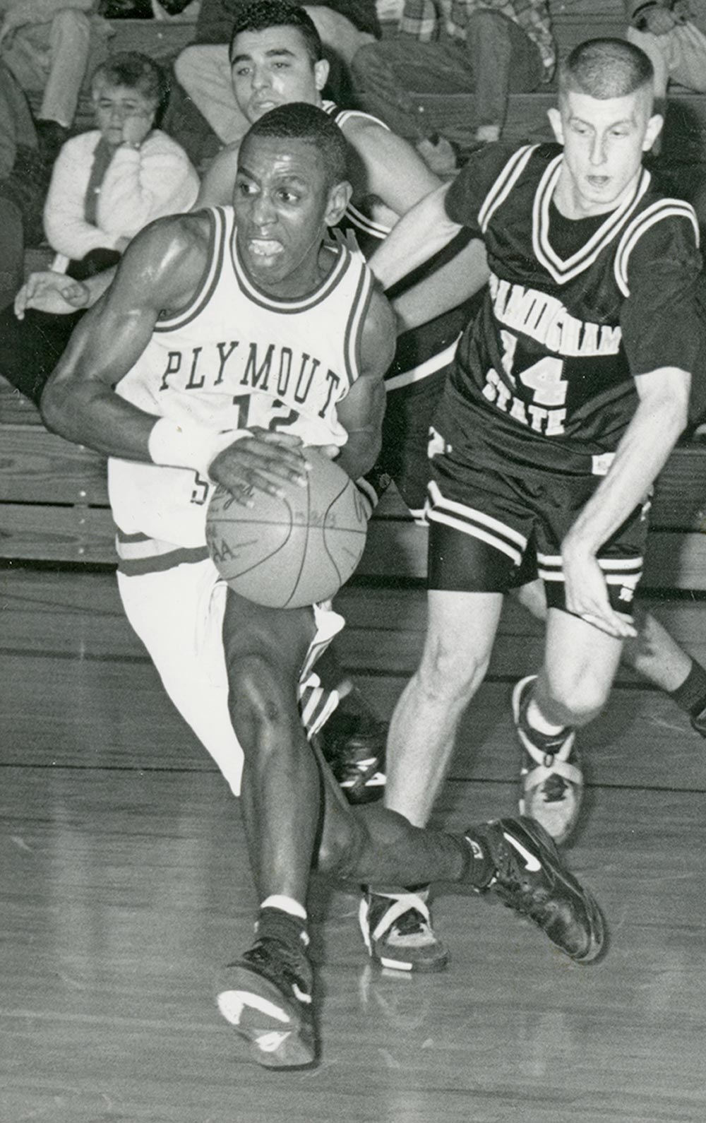 black and white image of Moses Jean-Pierre in the middle of playing a basketball game