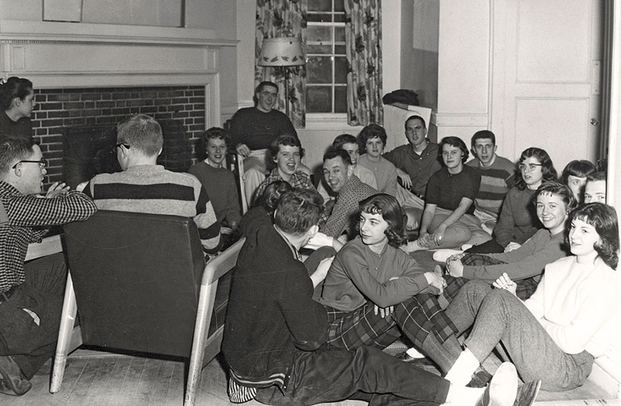 Student gathering in front of fireplace