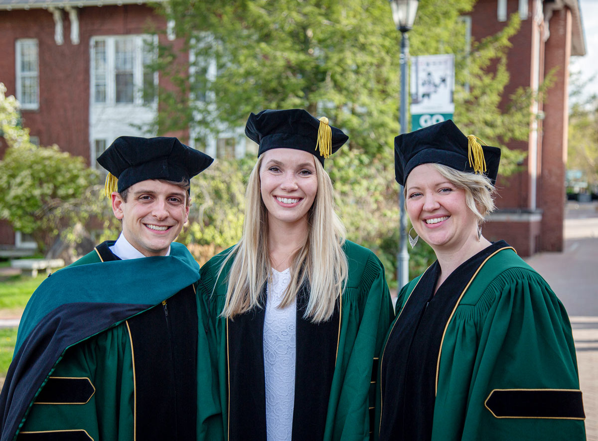 Three people posing for a picture together at the 150th commencement