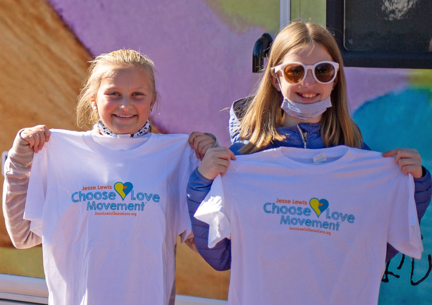 two young girls smile holding "ChooseLove Movement" t-shirts