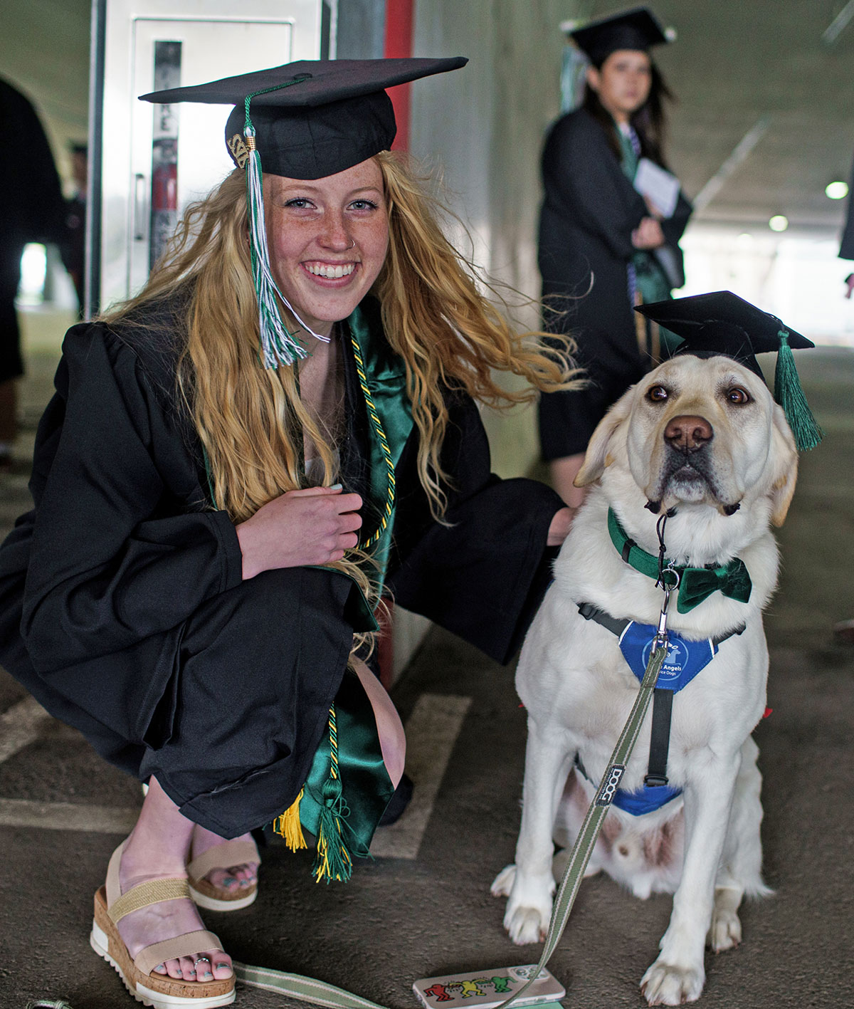 Graduate posing with her service dog