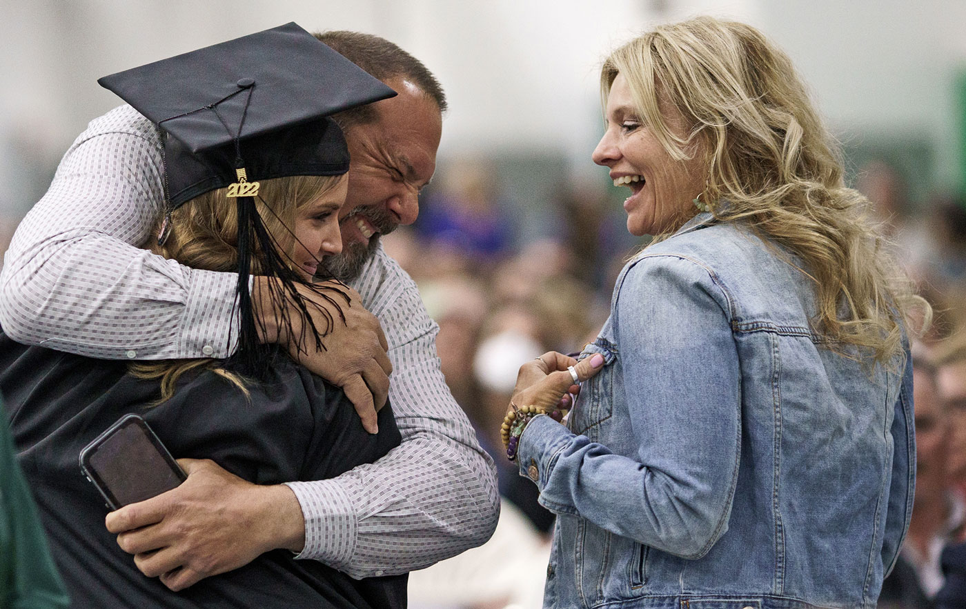 Graduate hugging her family