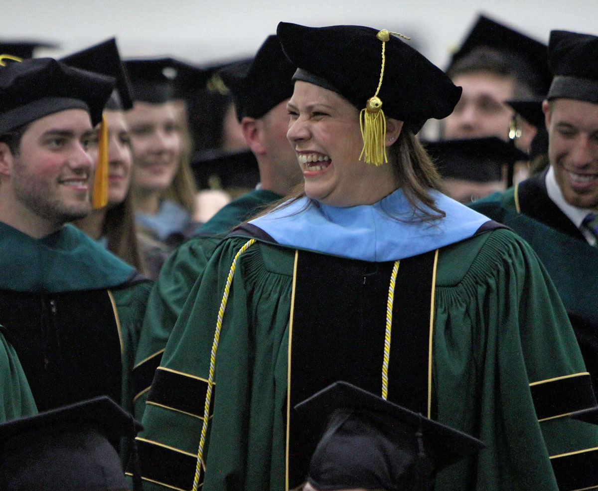 Graduate smiling in group of other graduates