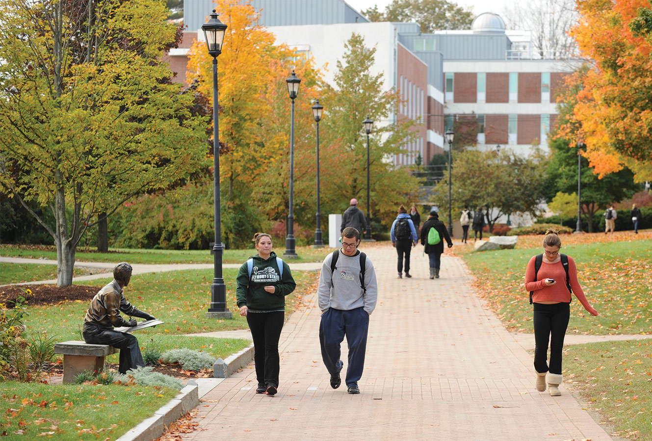 A group of students walking on campus; an autumnal background