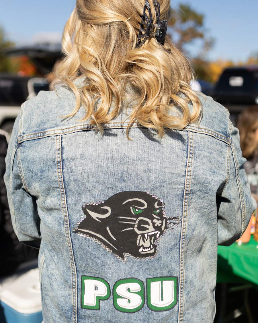 Girl wearing a PSU denim jacket with a panther on it