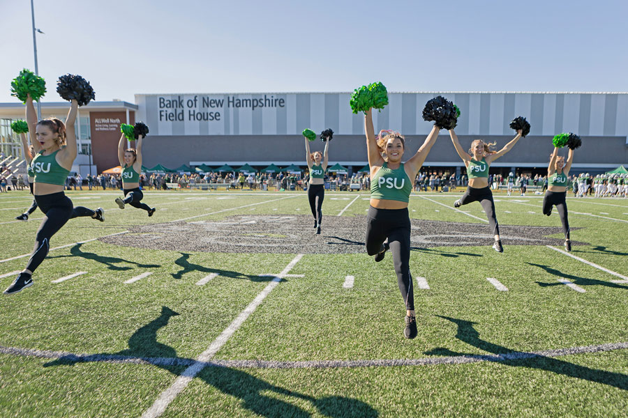 Cheerleaders mid jump on the football field