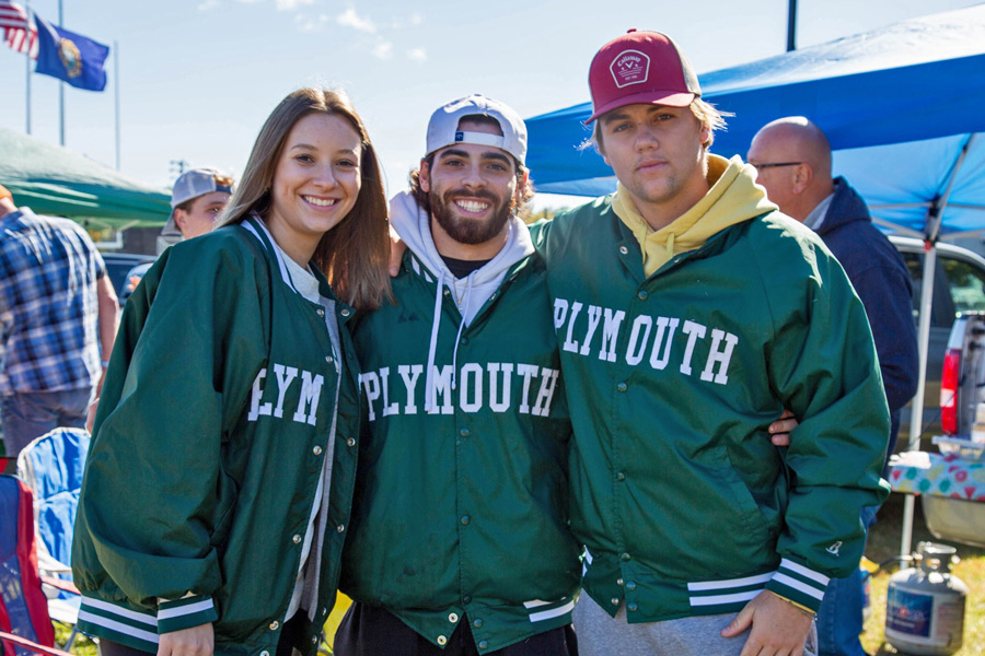 Three students wearing green Plymouth jackets