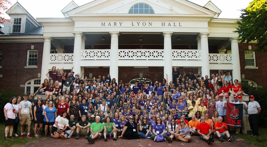 Plymouth State Greek Alumni in front of the Mary Lyon Hall