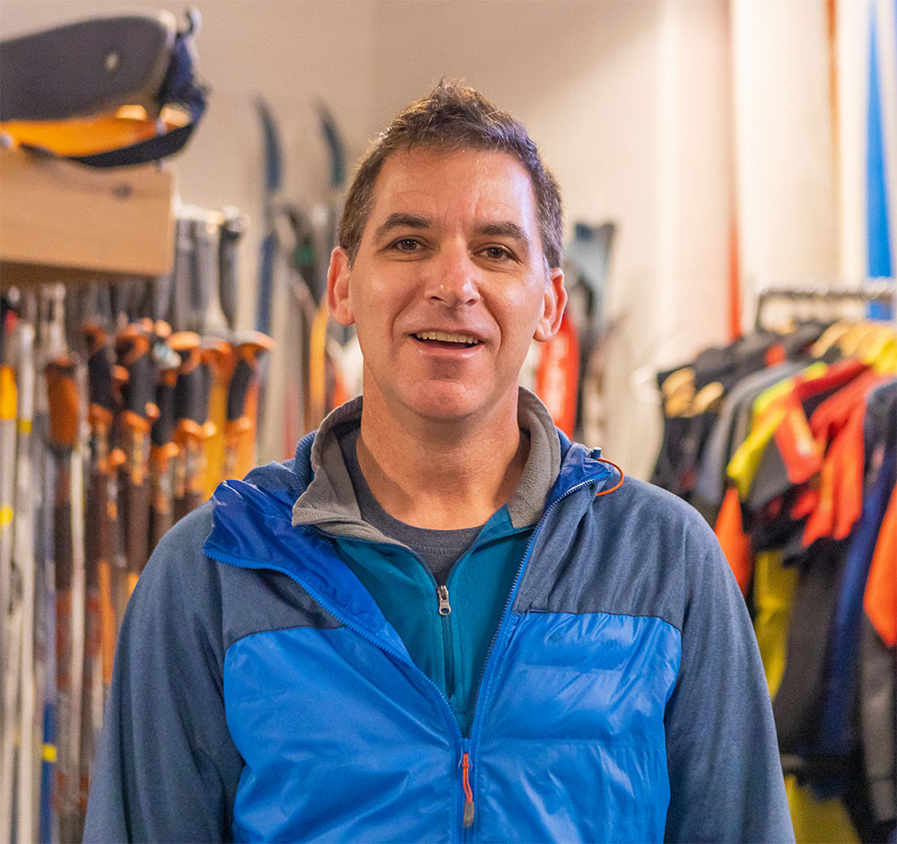 Craig Paiement, Outdoor Center director with skis and coats in background