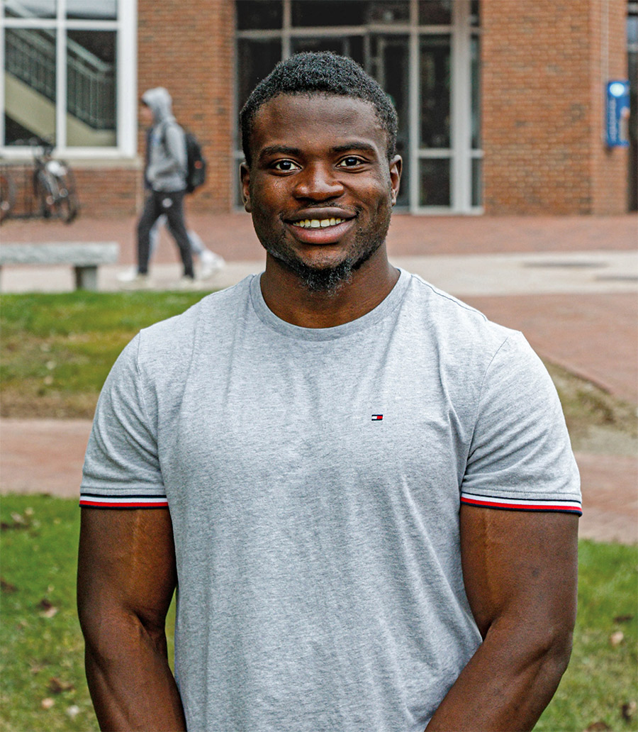 Sam Taksar in grey tshirt in front of Plymouth building