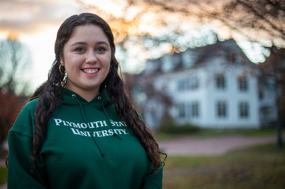 female student in a green Plymouth State University hoodie