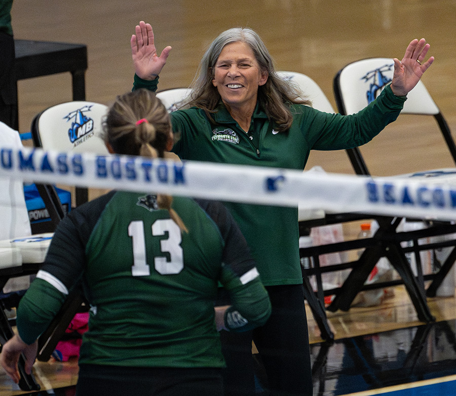 Coach Joan Forge going to high five student on court during game